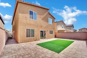 A two-story house with a paved patio and a small lawn. - 3000SF Modern Home｜FiberWiFi｜King Bed｜NearStrip (Las Vegas)
