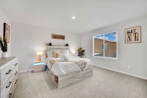 A bedroom with a bed, bedside tables, a dresser, and a window with blinds. - 3000SF Modern Home｜FiberWiFi｜King Bed｜NearStrip (Las Vegas)