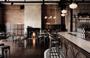 A bar area with a fireplace, seating, and a bar counter with taps. - The Avenue - Brand New Luxury, Walk to Main Street (Mornington)