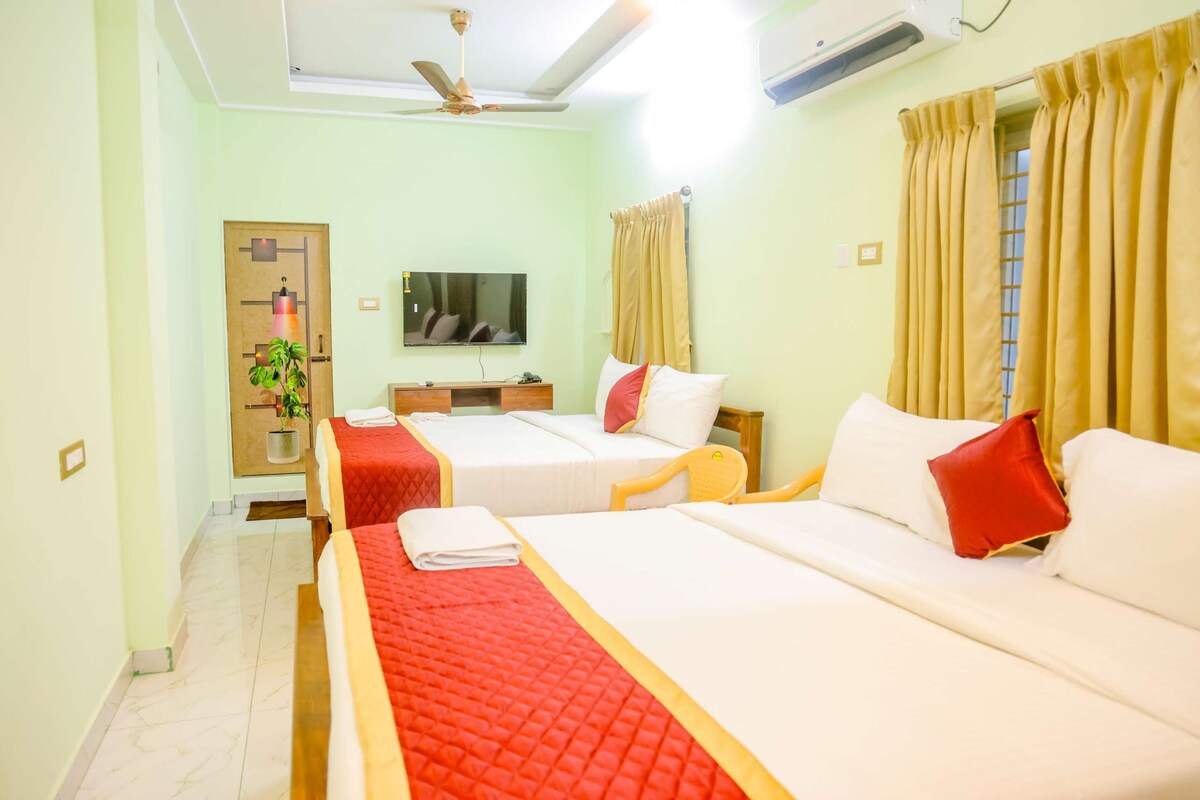 A hotel room with two beds, a television, a ceiling fan, and a window with curtains.