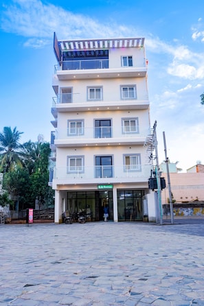 Un edificio de varios pisos con entrada a nivel de calle, un letrero que indica 'S.A. Residency' y una escalera que conduce a los pisos superiores.