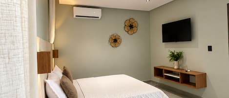 Une chambre à coucher moderne avec un lit, des tables de chevet, un téléviseur et une étagère fixée au mur.