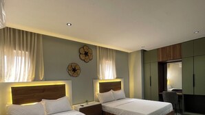 Quarto moderno com duas camas, uma escrivaninha e uma cadeira.