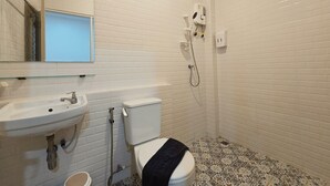 A bathroom with a white sink, a toilet, and a shower.
