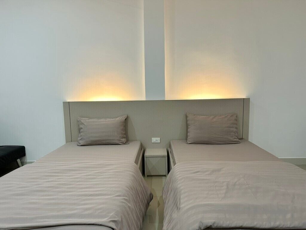 Ett hotellrum med två sängar, var och en med en sänggavel och ett nattduksbord.