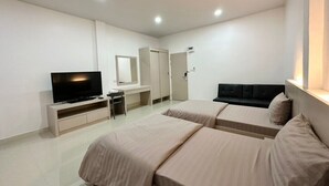 A hotel room with two beds, a TV, a desk, and a wardrobe.