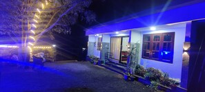 A house with a porch, potted plants, and string lights. - Serene 4-bedroom house in charming Suryanelli perfect for relaxing getaway (Suryanelli)