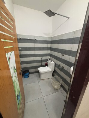 A small bathroom with a toilet, a shower, and a sink. - Serene 4-bedroom house in charming Suryanelli perfect for relaxing getaway (Suryanelli)