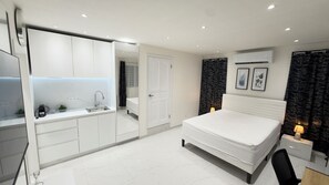 A modern bedroom with a bed, bedside table, and a built-in wardrobe. - The Little Heaven Retreats - Studio (Saint-martin)