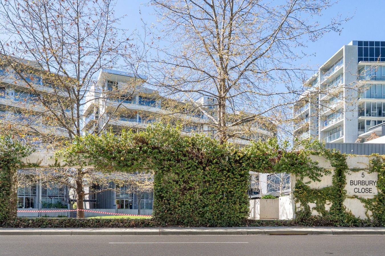 A welcoming view of the modern building surrounded by greenery, highlighting the peaceful and well-kept setting of the property.