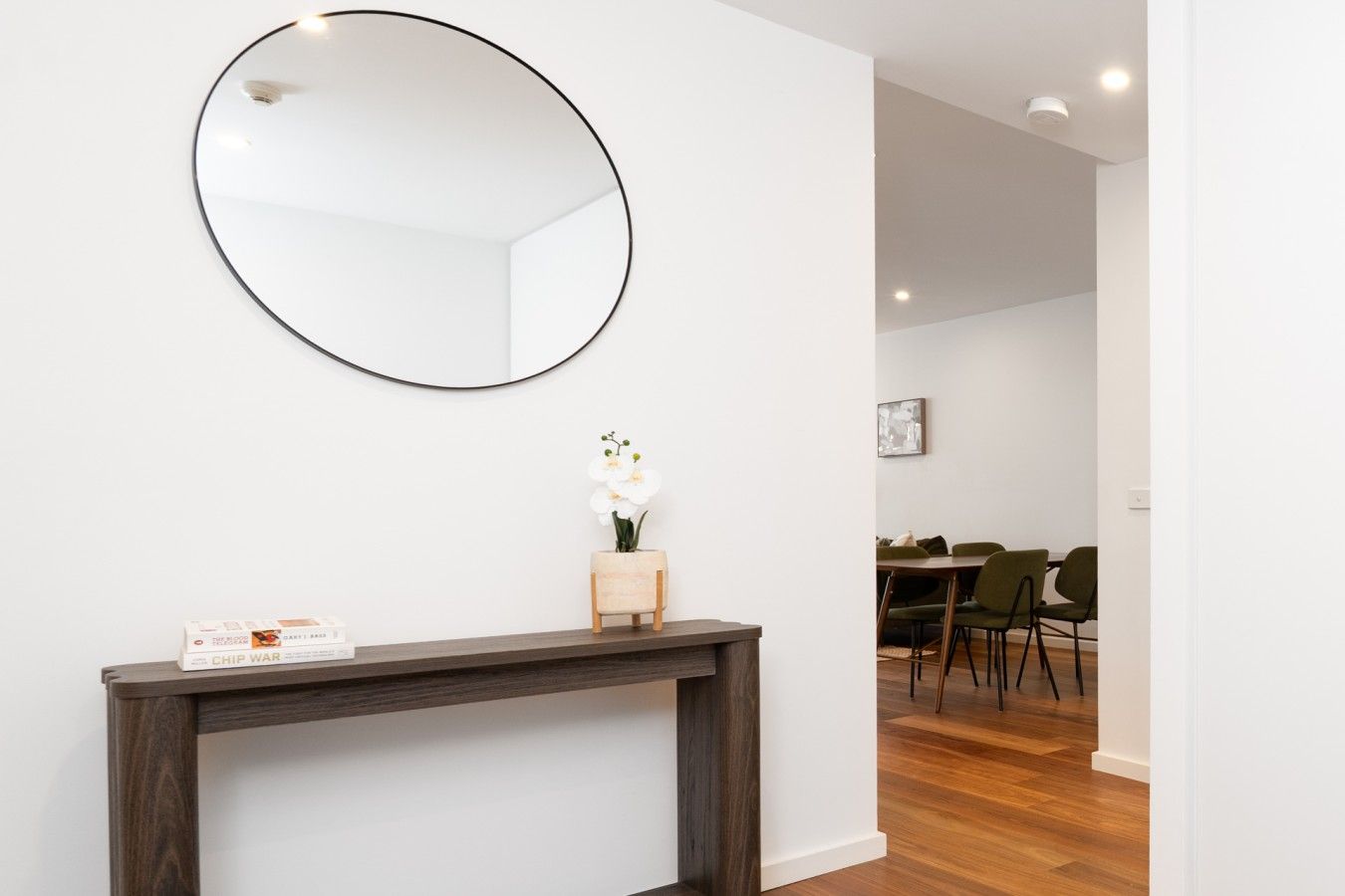 A charming entrance with a round mirror and timber console, adding a touch of warmth and character as you arrive home.