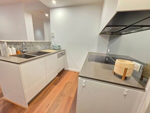 A compact kitchen with a built-in dishwasher, a sink, and a small countertop. - Balcony, Dining and 2 Car Spaces (Barton)