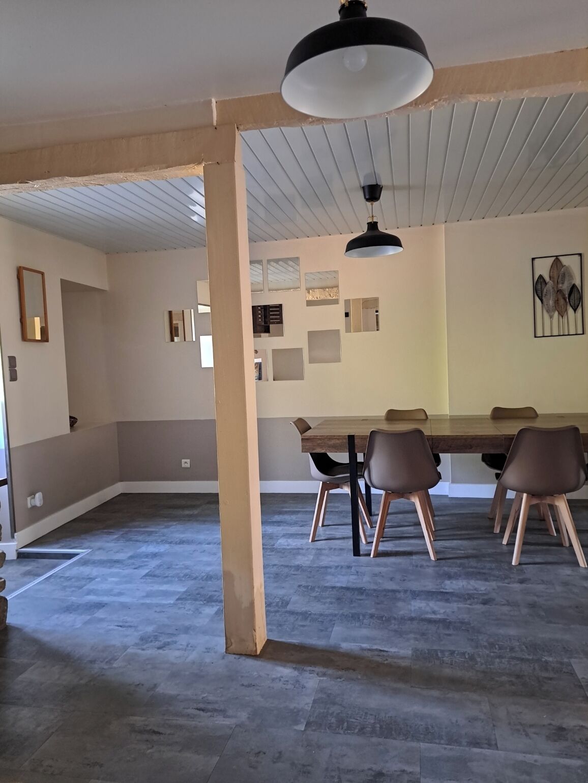A spacious room with a large dining table, several chairs, and a ceiling fan.