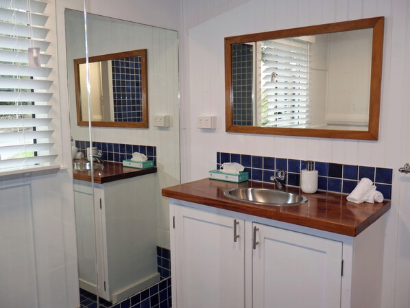 A bathroom with a sink, mirror, and cabinets.
