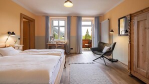 Ein Hotelzimmer mit zwei Betten, einem Schreibtisch und einem Stuhl.