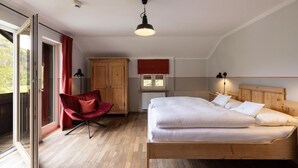 Ein Schlafzimmer mit Bett, Stuhl, Kleiderschrank und Fenster.