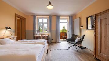 Ein Hotelzimmer mit zwei Betten, einem Schreibtisch und einem Stuhl.