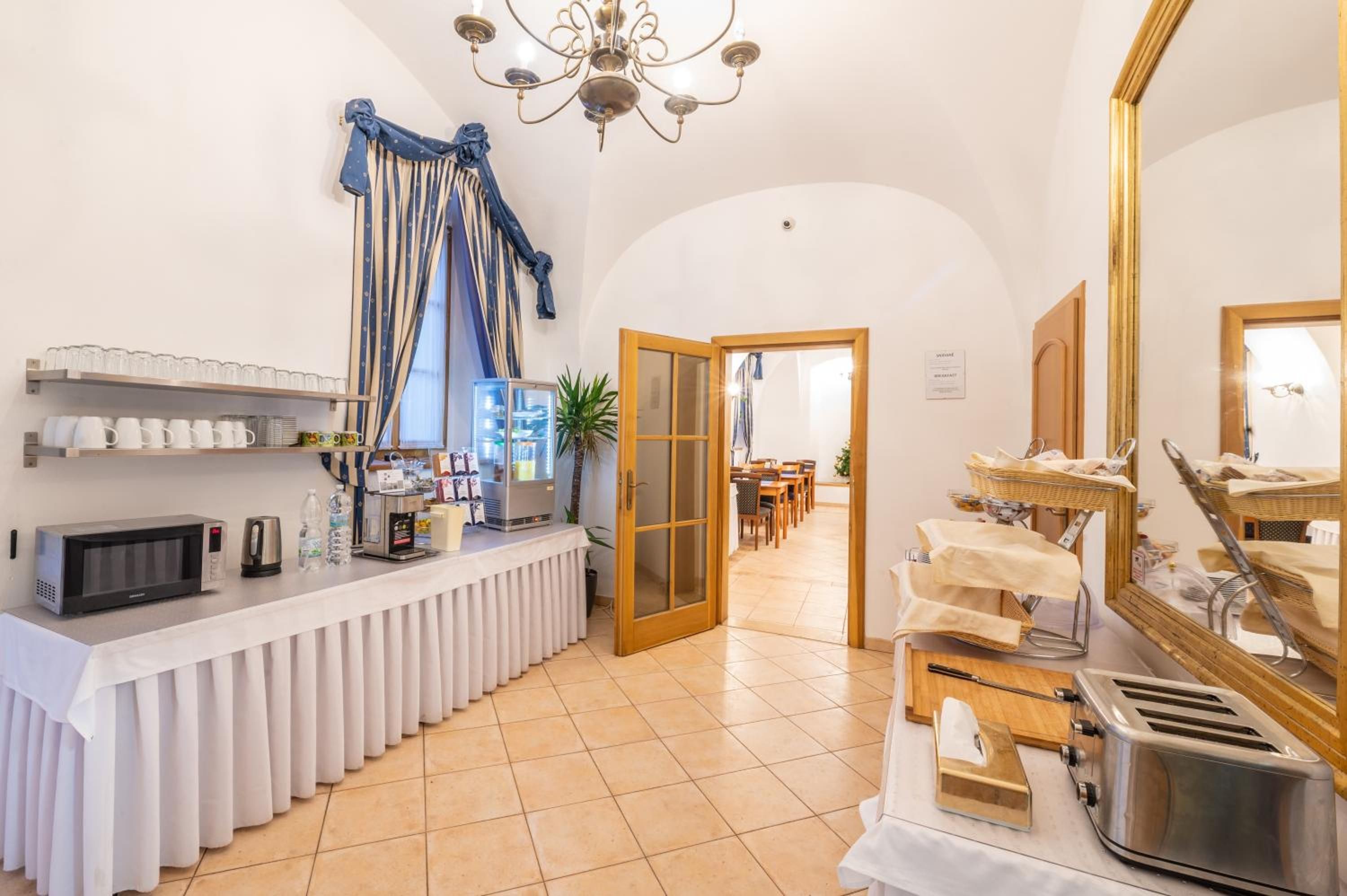 Una cocina de hotel con barra de buffet, microondas, cafetera y tostadora.