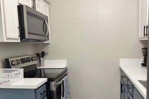 Una cocina equipada con microondas, horno y armarios.