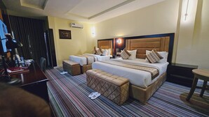 Habitació d'hotel amb un llit gran, dues taules de nit, un escriptori i una cadira.