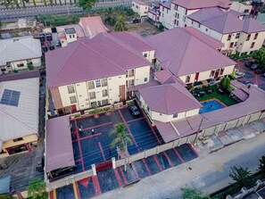 A residential area with multiple buildings, a parking lot, and a road in the background. - Villa Hilton Hotels and Apartments (Uyo)