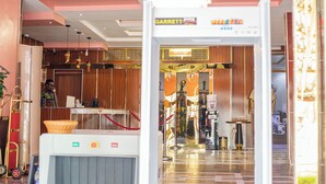 Rebedor d'hotel amb taulell de recepció, un dispensador d'aigua i vista de l'interior de l'hotel.