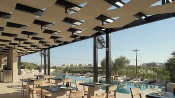 Un área de piscina al aire libre con sillones y mesas, rodeada por una estructura de pérgola.