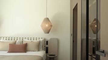 A modern bedroom with a bed, bedside table, and a hanging light fixture.