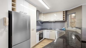 Eine moderne Küche mit einem Edelstahlkühlschrank, einem Einbauofen und einem Geschirrspüler.