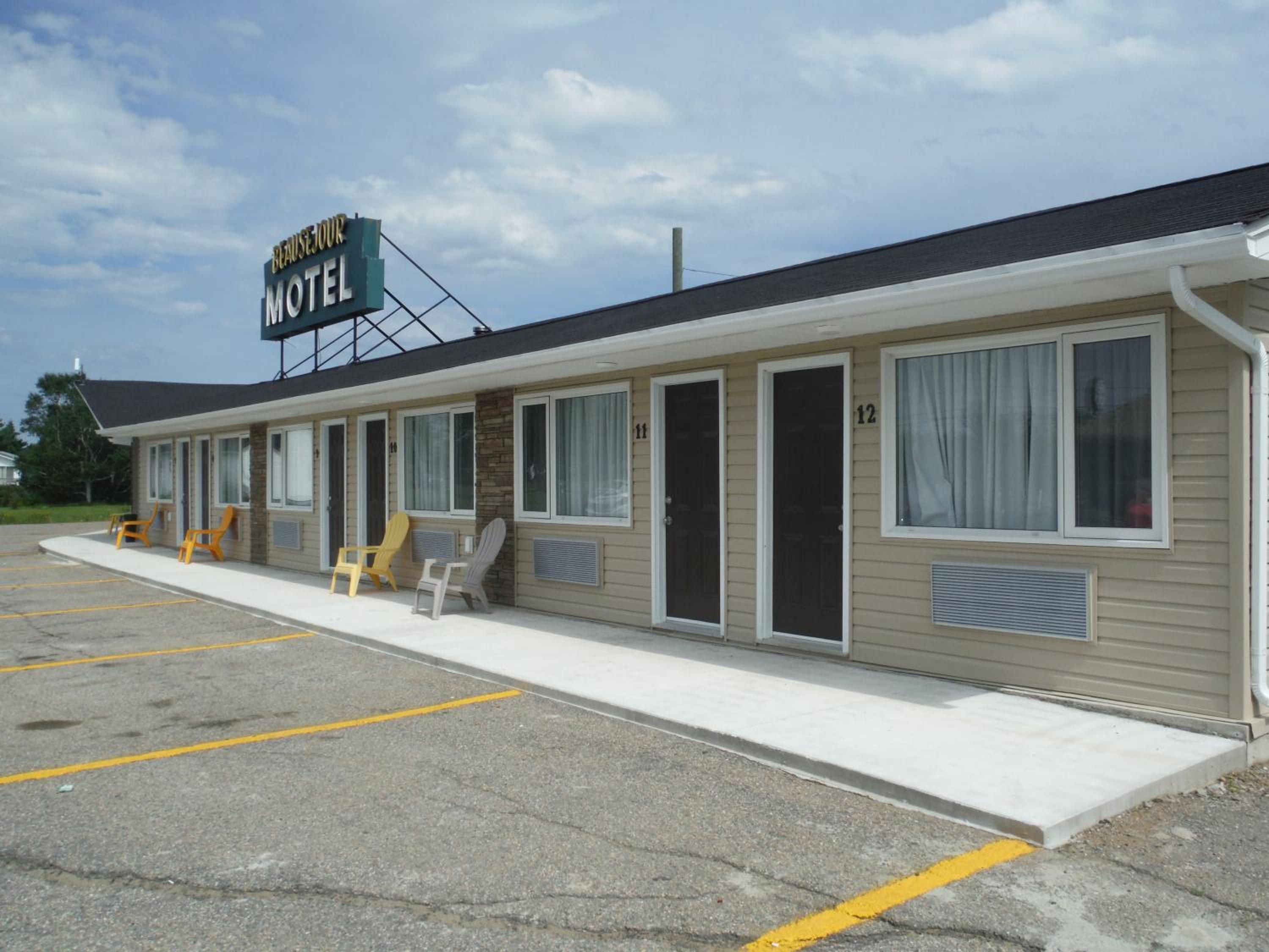 A motel with numbered rooms, a parking lot, and outdoor seating.