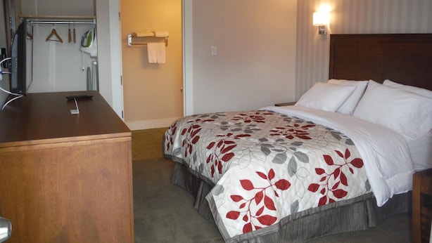 Ein Hotelzimmer mit einem Bett, einem Schreibtisch und einem Spiegel.