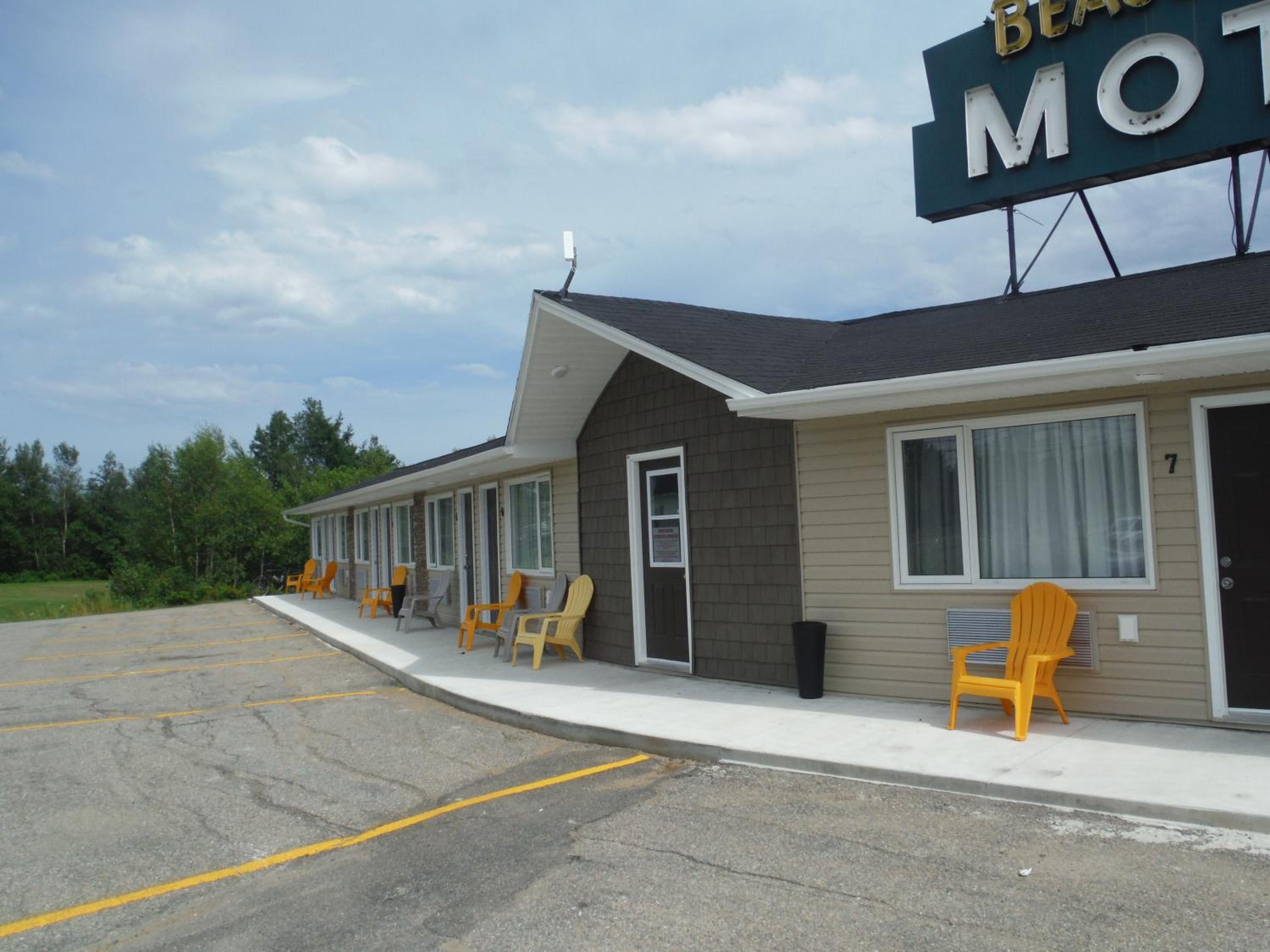 A motel with a row of rooms, each with a door and windows.