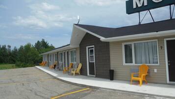 A motel with a row of rooms, each with a door and windows.