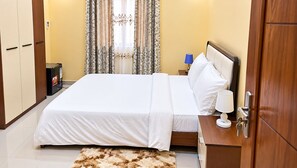 Ein Hotelzimmer mit Bett, Nachttisch, Lampe und Schrank.