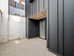 Ein modernes Gebäude mit Kiesgrund, einem Holzbalken und einer Glasdoor.