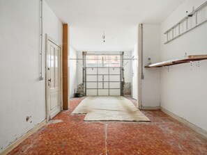 Ein schmales Dielen-Foyer mit einer Tür links und einem Fenster am Ende.