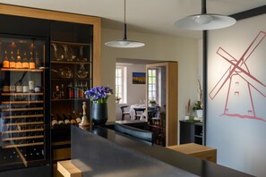 Una cocina moderna con una cava de vinos, un jarrón de flores y un comedor visible a través de una puerta abierta.