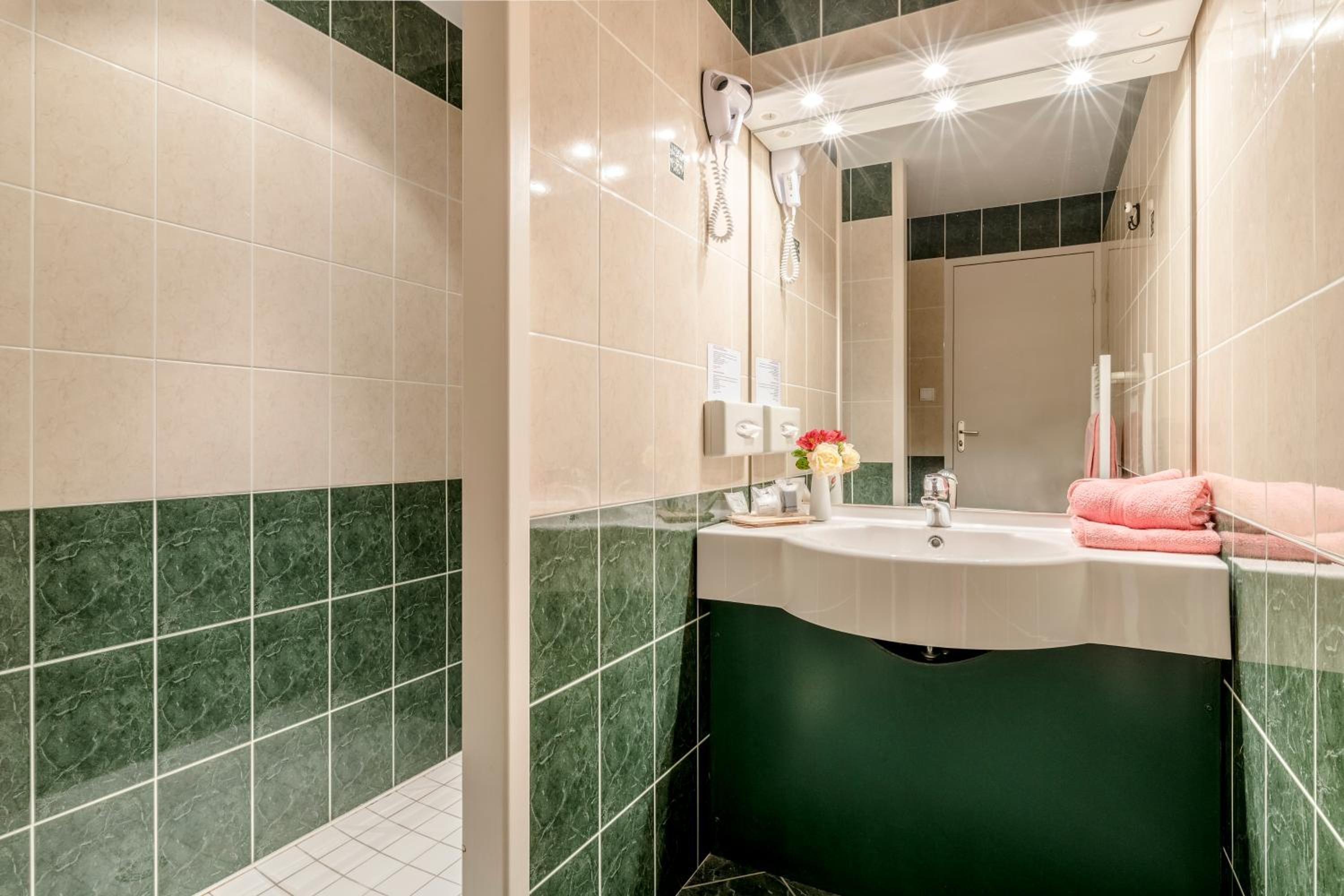 Une salle de bain avec un lavabo, un miroir et un porte-serviettes.