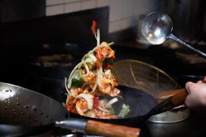 Una escena de cocina con un wok, una espumadera y una espátula.