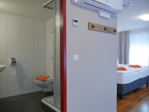 Un ba ño moderno con ducha, inodoro y lavamanos.