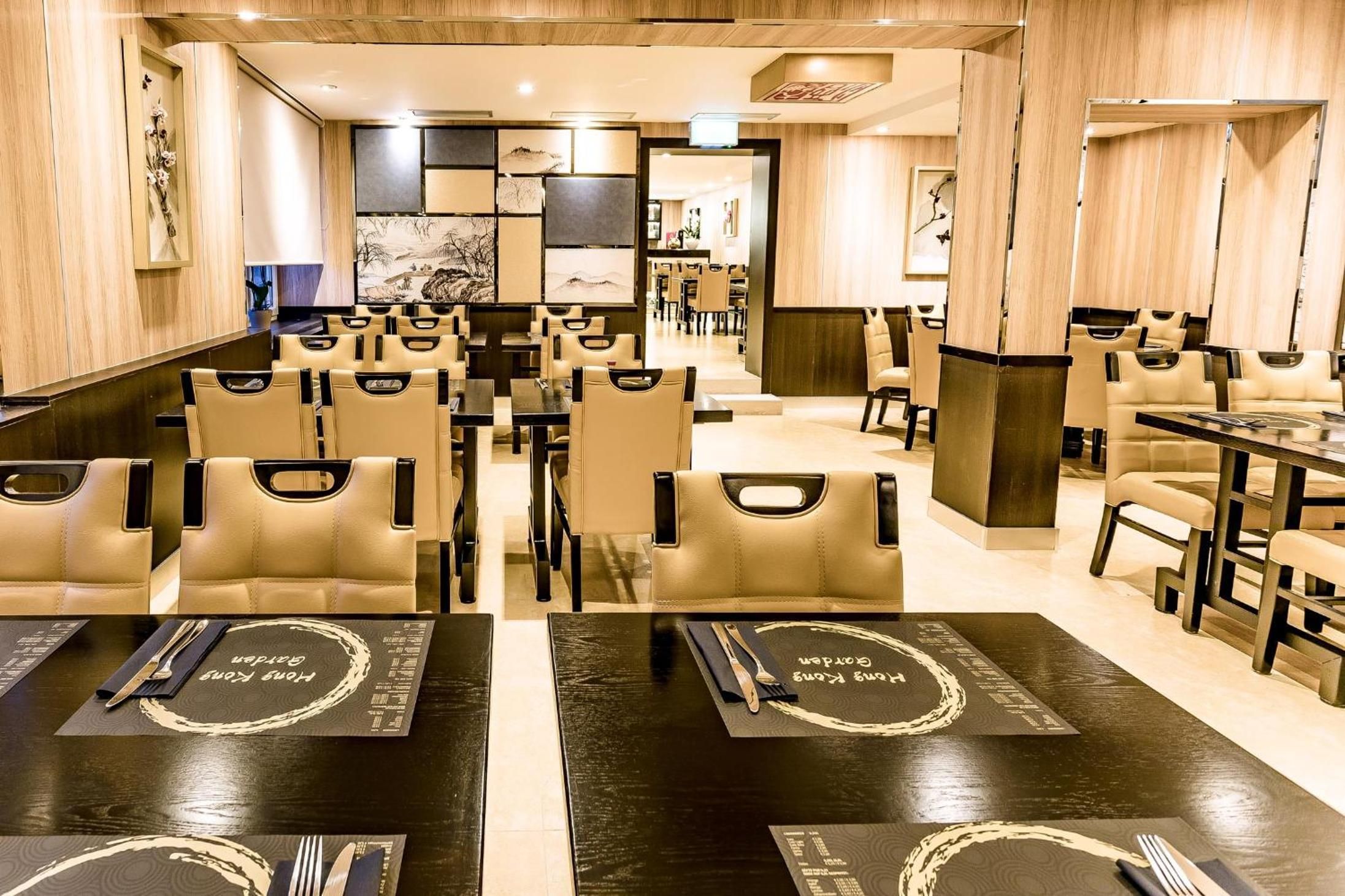 A restaurant with multiple tables and chairs, some with menus on them.