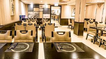 A restaurant with multiple tables and chairs, some with menus on them.