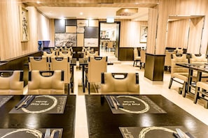 Un restaurante con varias mesas y sillas, algunas con menús.