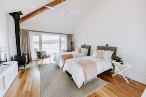 A bedroom with two beds, a large window, and a view of the outdoors. - The Homestead (Berry)