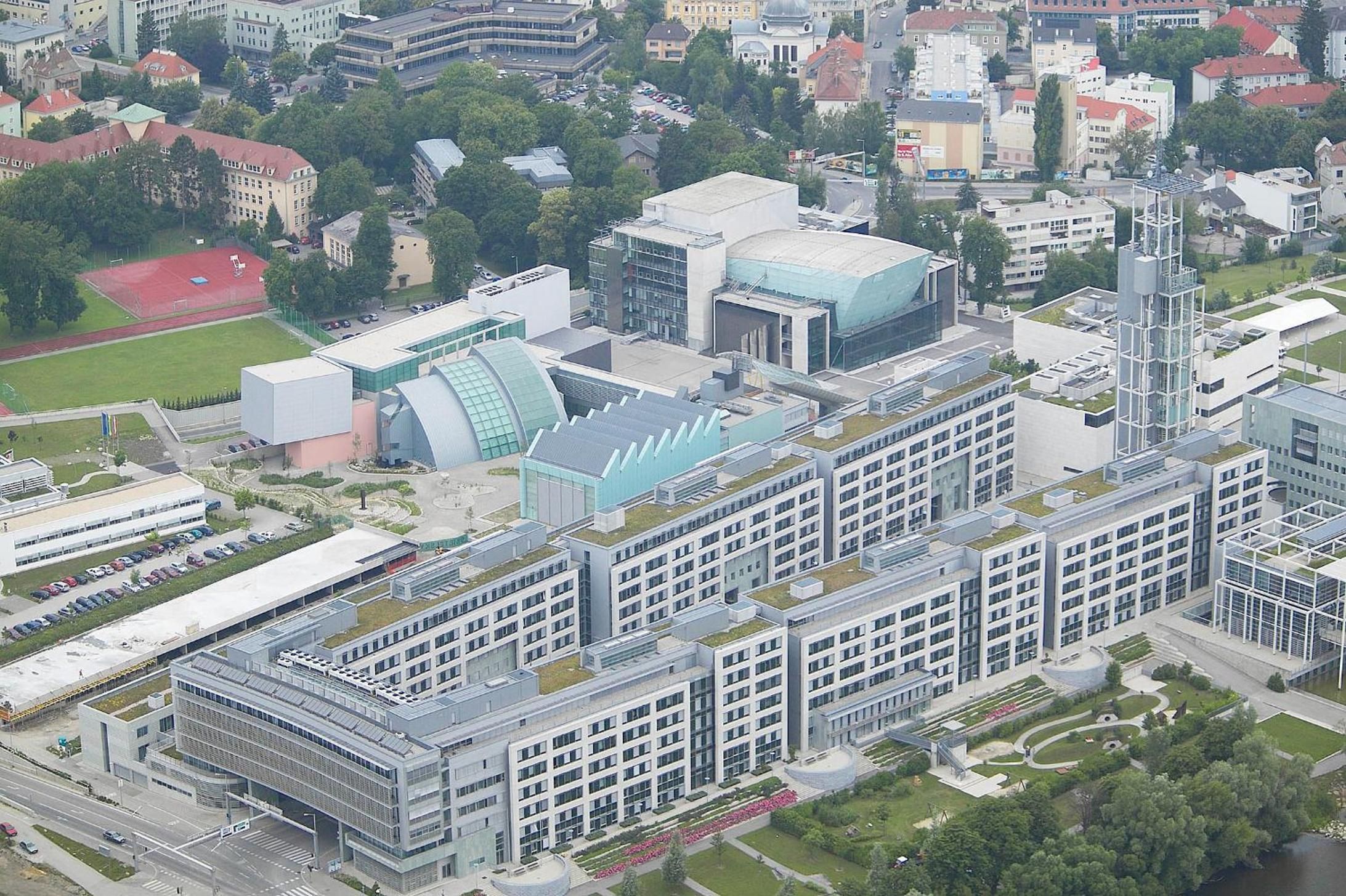 A modern building complex with multiple structures, including a large glass dome and a tall tower.