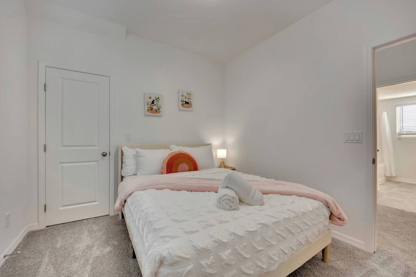 Une chambre à coucher avec un lit, une porte et une table de chevet avec une lampe.
