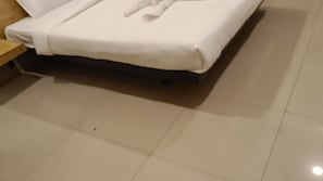 A bed with a white mattress and a wooden headboard. - Hotel Sriveda By DebAsh Hospitality  (Hyderabad)