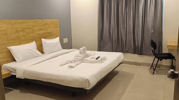 Une chambre d’hôtel avec un lit, une chaise et une porte.