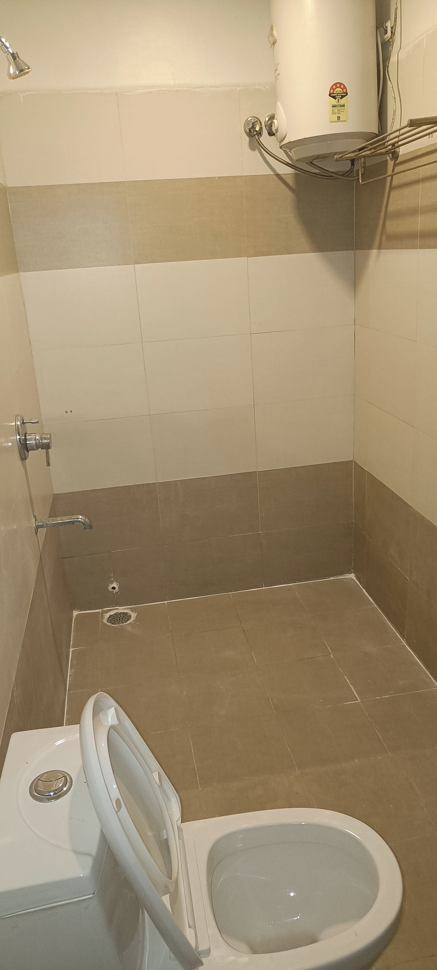 A bathroom with a toilet, a shower, and a sink.