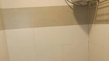 A bathroom with a toilet, a shower, and a sink.